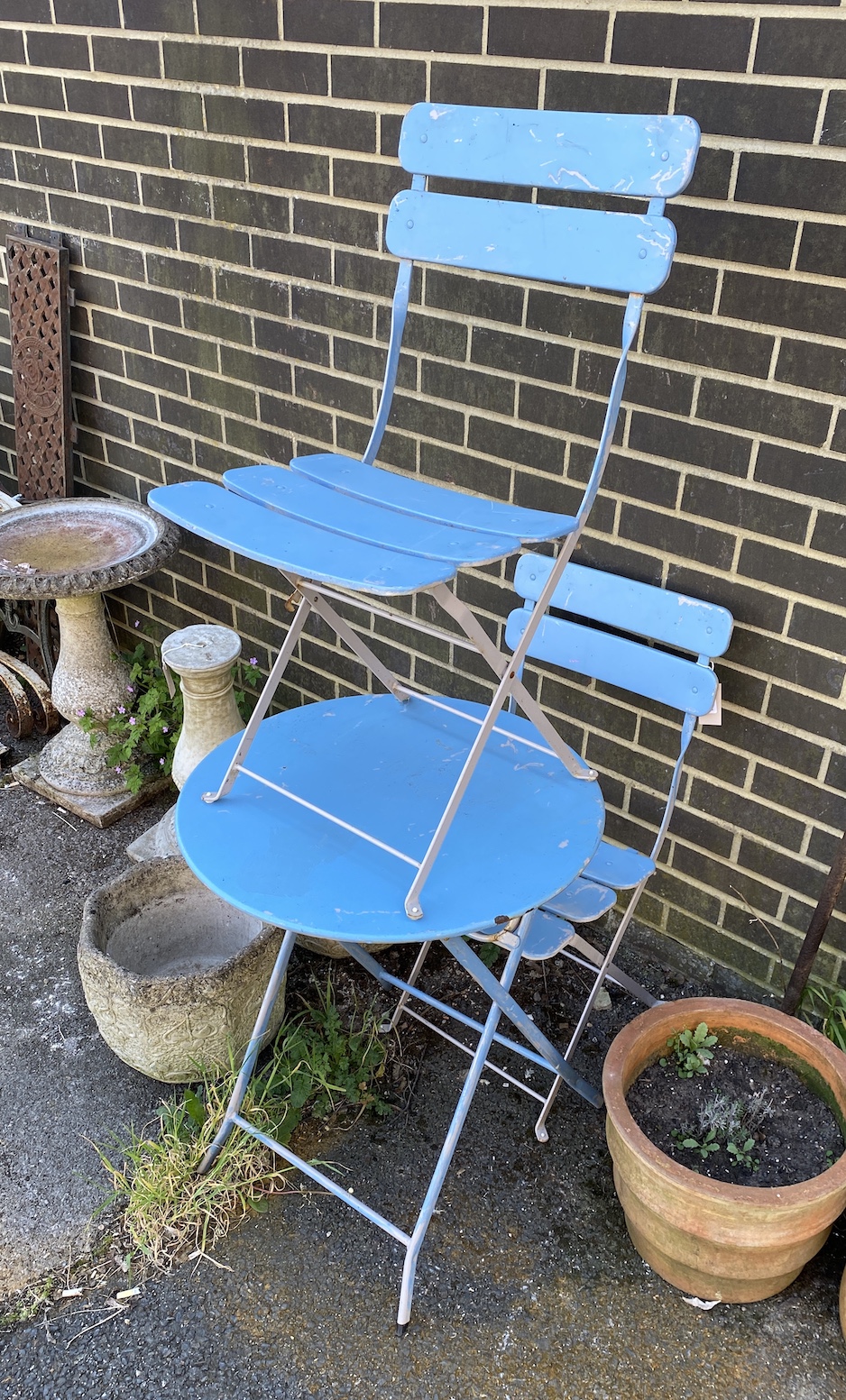 A painted folding garden table, diameter 60cm, height 71cm, and a pair of folding chairs